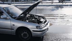 Vanha konepelti auki. Jäänyt tienposkeen kun ei lähde auto käyntiin.